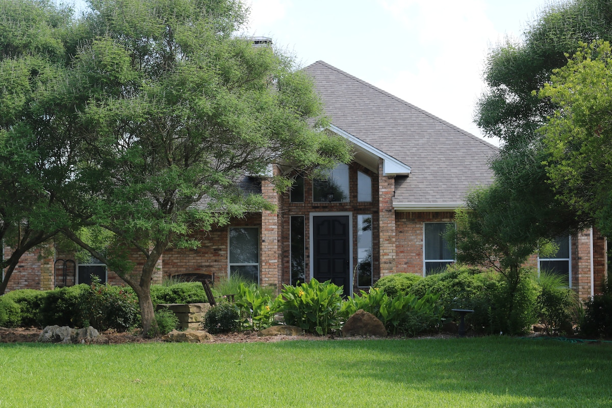 Brick farmhouse exterior with lawn