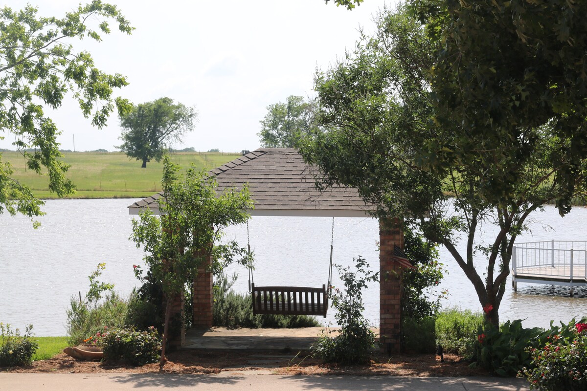 Garden bench beneath shade trees by the pond